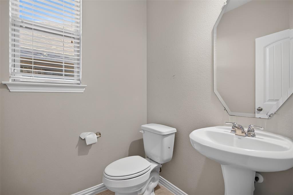 2066 Avondown Road Forney, TX 75126 - Photo 5 of 33 Neutral-toned powder room featuring a white pedestal sink with chrome faucet, a white toilet, and a window with blinds