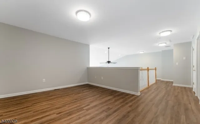 a view of a room with wooden floors and ceiling fan