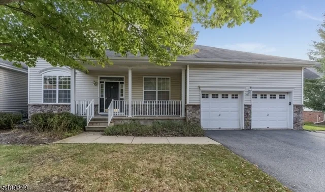 a view of a house with a small yard plants and large tree