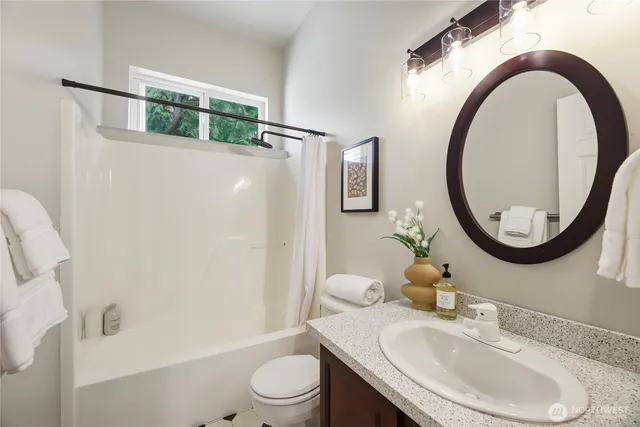 a bathroom with a sink a toilet and a mirror