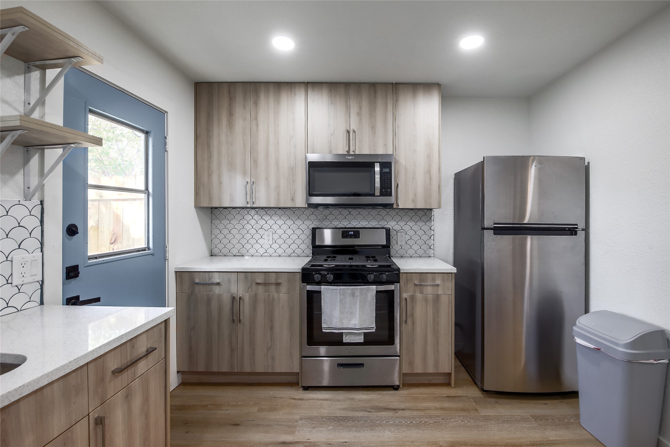 10509 Macmora Road, Unit A Austin, TX 78758 - Photo 6 of 17 Modern kitchen with streamlined cabinetry, stainless steel appliances, and a captivating backsplash design.