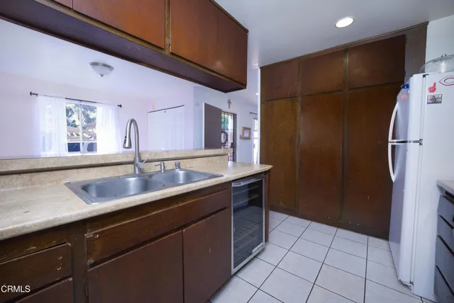 a kitchen with a sink a refrigerator and cabinets