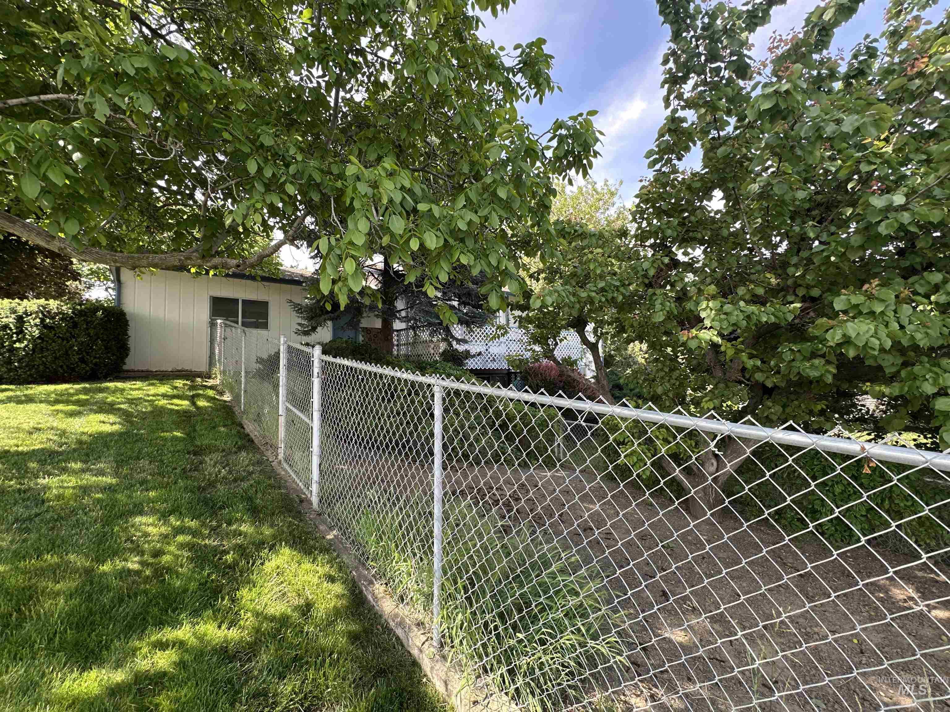 1620 6th Avenue Clarkston, WA 99403 - Photo 4 of 19 Chain link fencing bordering a grassy area with mature trees