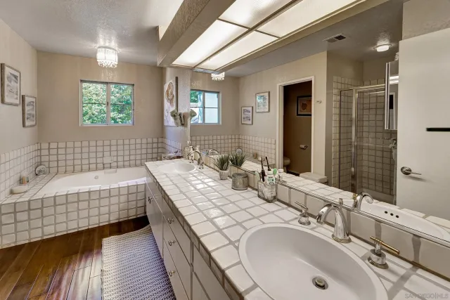 a bathroom with a tub double vanity sink and a mirror