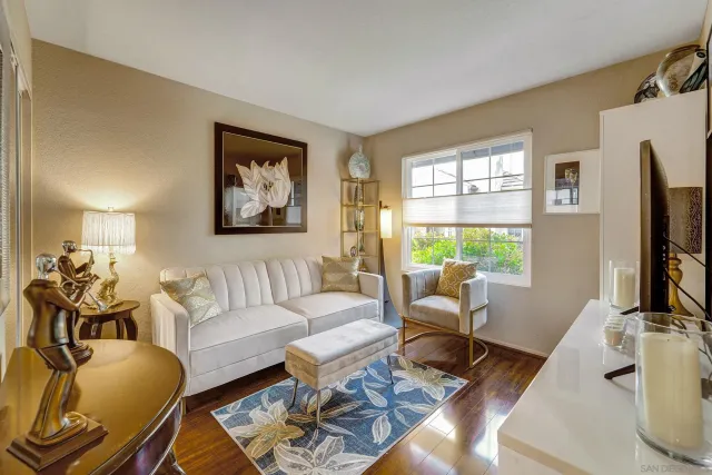 a living room with furniture a flat screen tv and a window