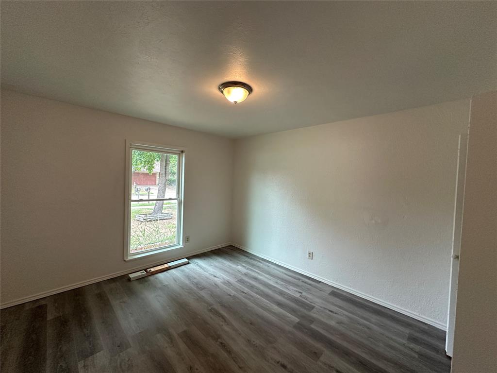 910 Sunny Slope Drive Allen, TX 75002 - Photo 13 of 27 an empty room with wooden floor and windows