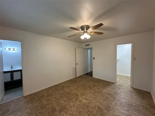 an empty room with a chandelier fan and a chandelier fan