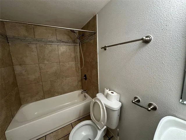 a bathroom with a tub a toilet and a shower