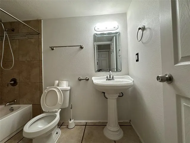 a bathroom with a toilet sink shower and mirror
