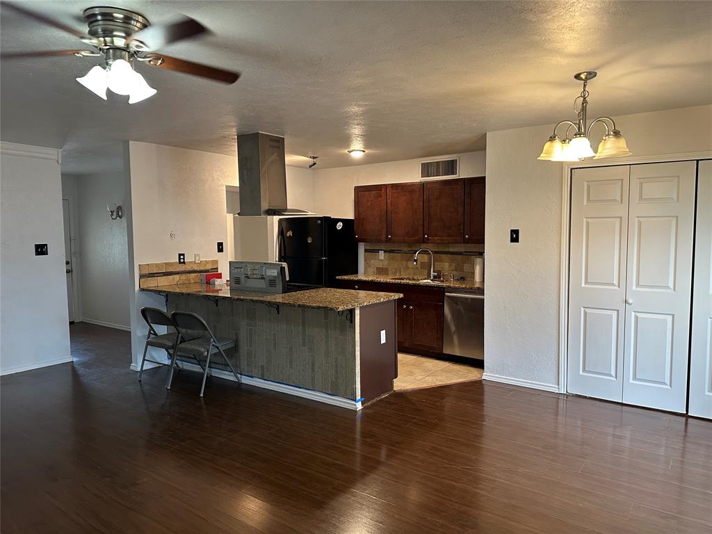 910 Sunny Slope Drive Allen, TX 75002 - Photo 3 of 27 a kitchen with kitchen island appliances cabinets and wooden floor