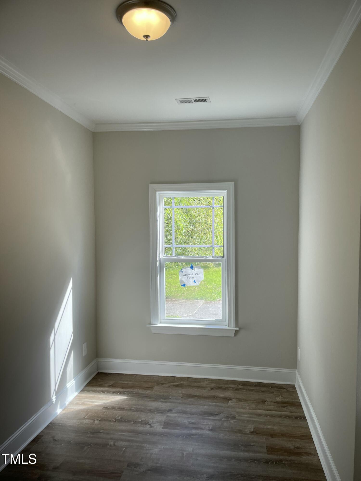 5500 Batoul Lane Raleigh, NC 27606 - Photo 12 of 32 a view of an empty room with wooden floor and a window
