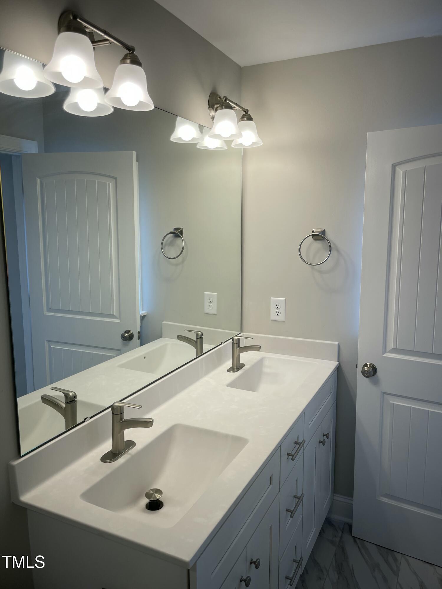 5500 Batoul Lane Raleigh, NC 27606 - Photo 22 of 32 a bathroom with a sink and a mirror
