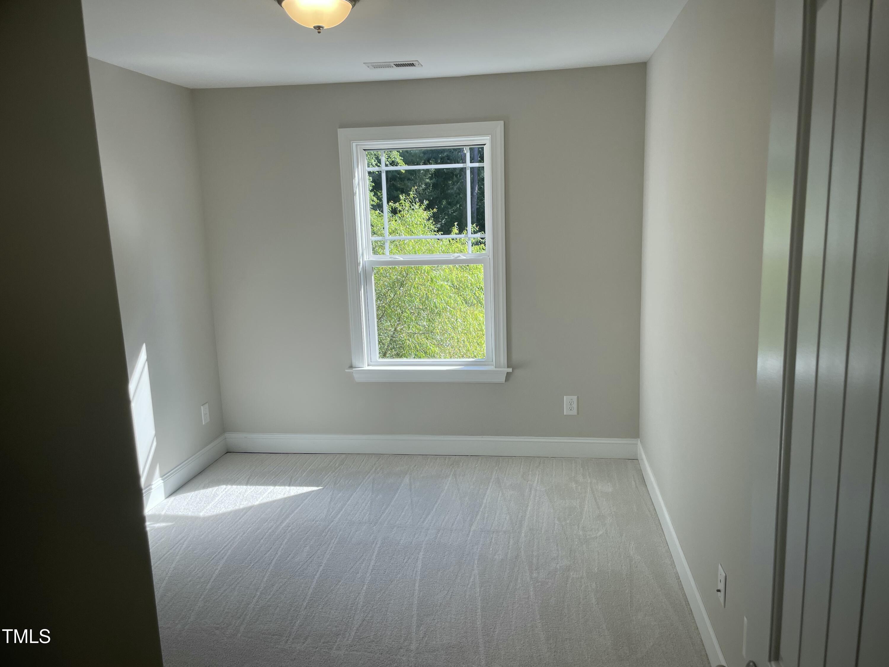 5500 Batoul Lane Raleigh, NC 27606 - Photo 26 of 32 an empty room with wooden floor and windows