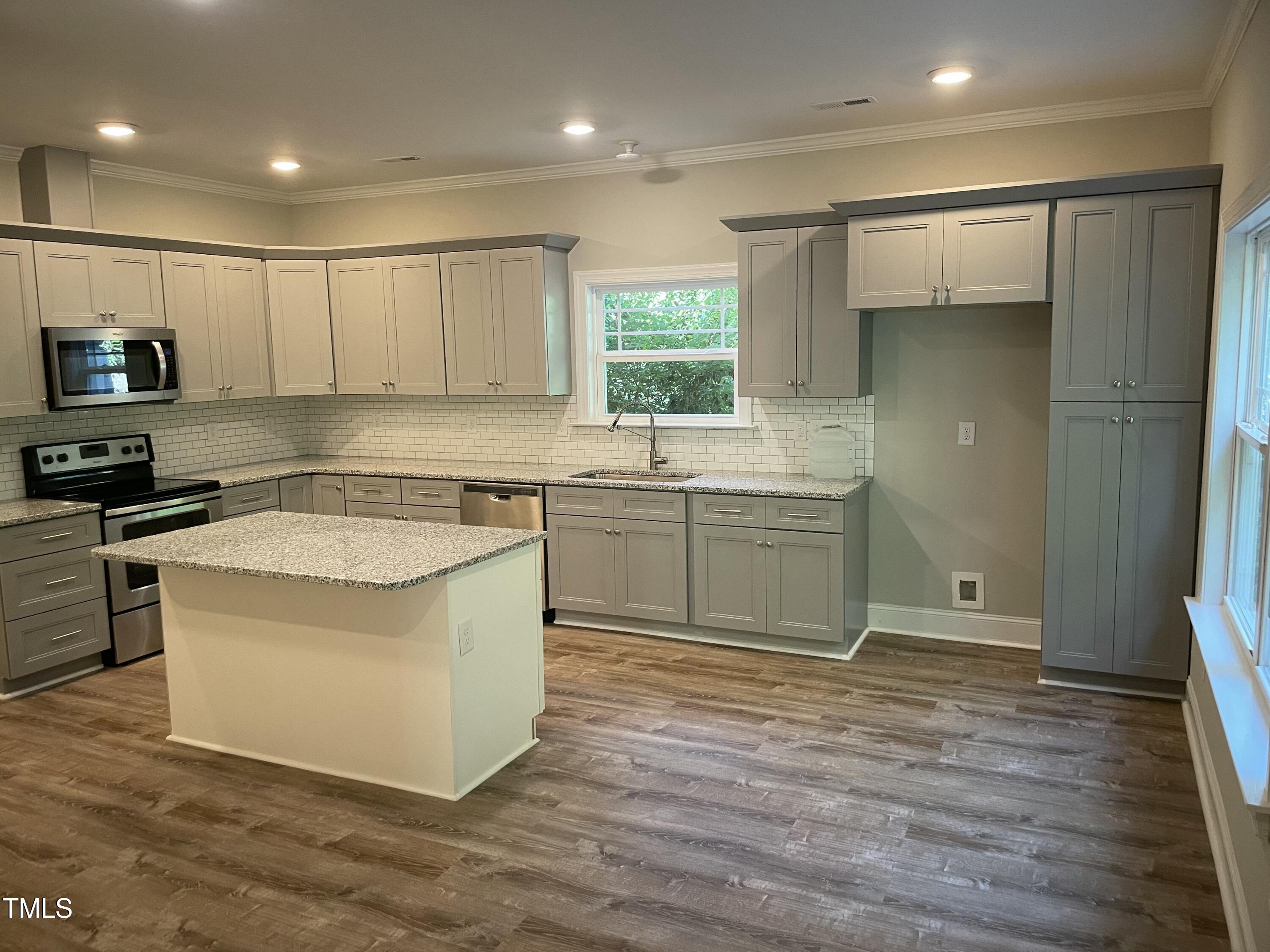 5500 Batoul Lane Raleigh, NC 27606 - Photo 4 of 32 a kitchen with a sink cabinets and wooden floor