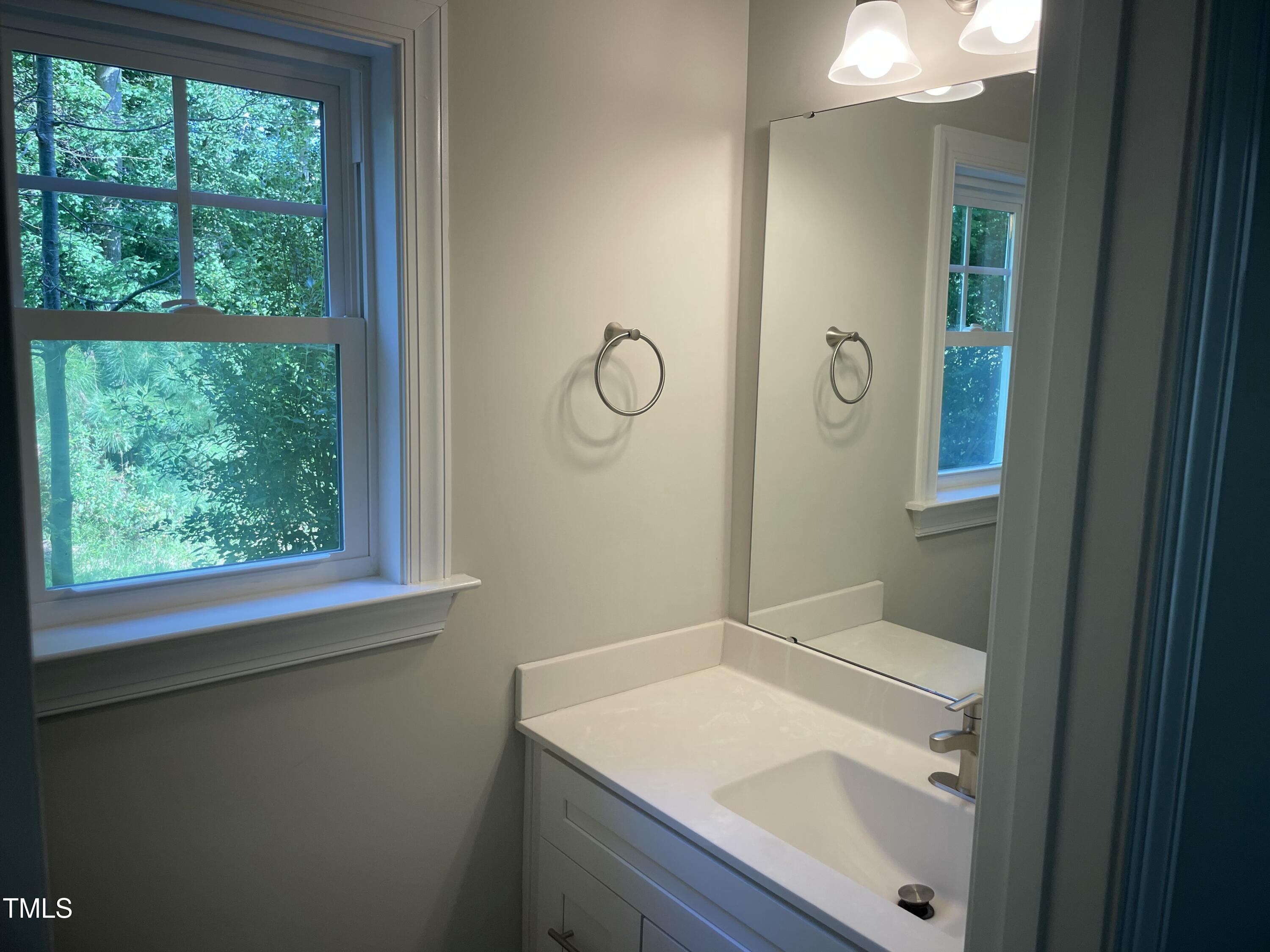5500 Batoul Lane Raleigh, NC 27606 - Photo 9 of 32 a bathroom with a sink vanity and a mirror