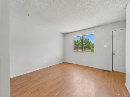 an empty room with wooden floor and window