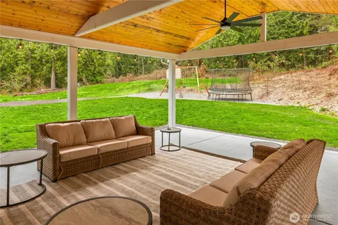a view of a patio with couches chairs and a big yard