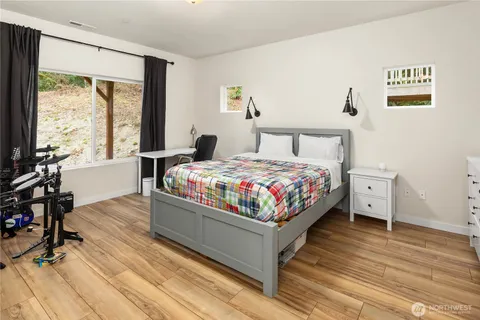 a bedroom with a bed and wooden floor