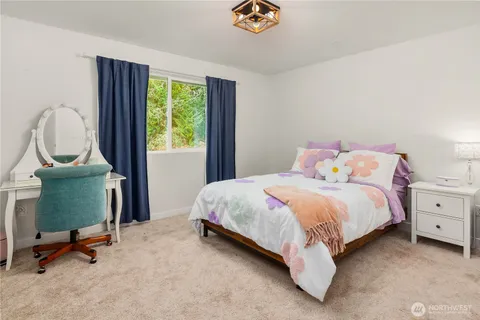 a bedroom with a bed dresser and a window