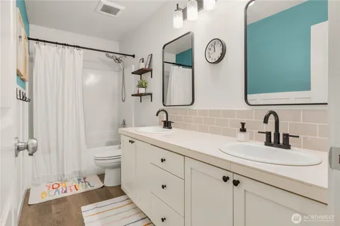 a bathroom with a granite countertop sink a toilet and a shower