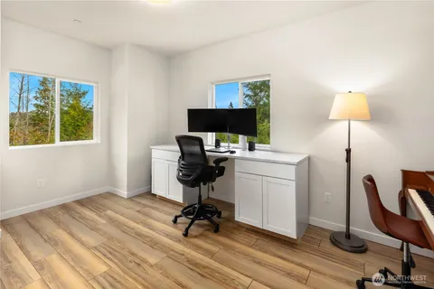 a view of a workspace with furniture and a window