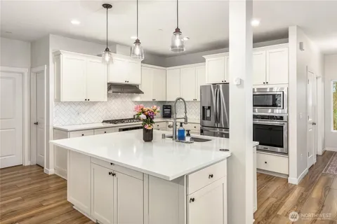 a kitchen with stainless steel appliances a sink a stove a refrigerator and cabinets