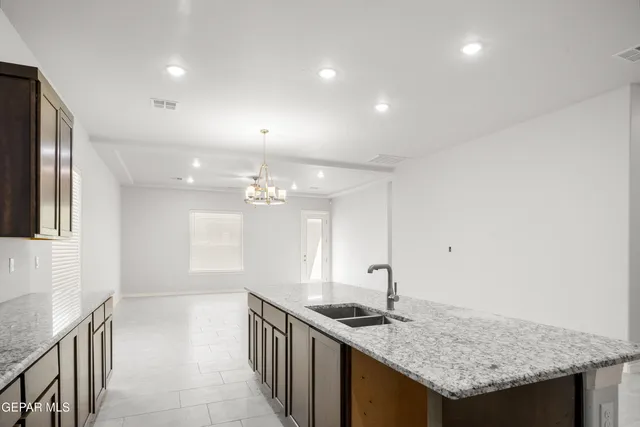 a kitchen with granite countertop kitchen island stainless steel appliances a sink stove and cabinets