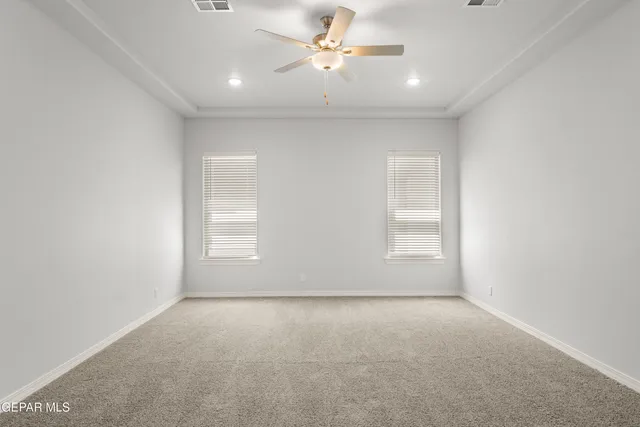 an empty room with a window and ceiling fan