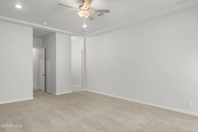 an empty room with a ceiling fan and a window