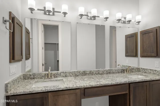 a bathroom with double vanity sinks and a mirror