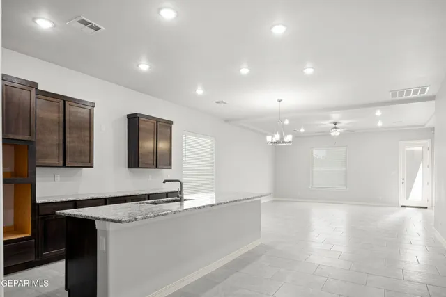 a large kitchen with stainless steel appliances a large counter top a stove and a refrigerator