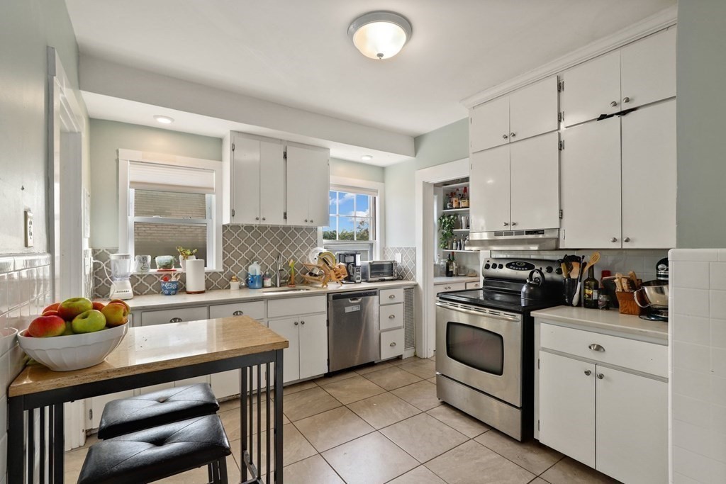 3 Clark Road Brookline, MA 02445 - Photo 9 of 24 a kitchen with white cabinets and appliances