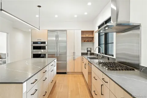 a kitchen with stainless steel appliances granite countertop a sink stove and refrigerator
