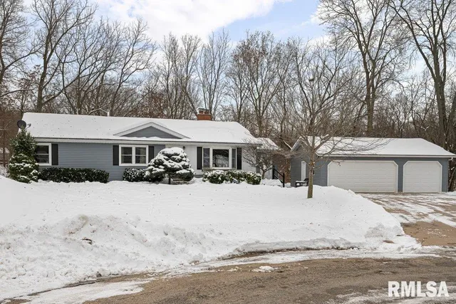 a front view of a house with a yard covered in snow