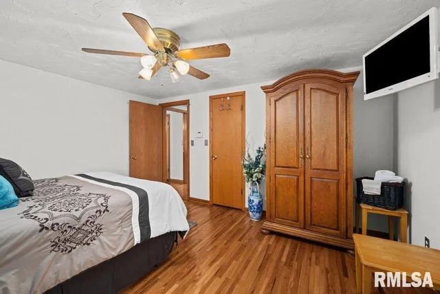 a bedroom with a bed and a wooden floor