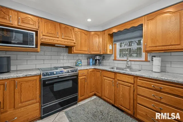 a kitchen with granite countertop cabinets stainless steel appliances and a sink