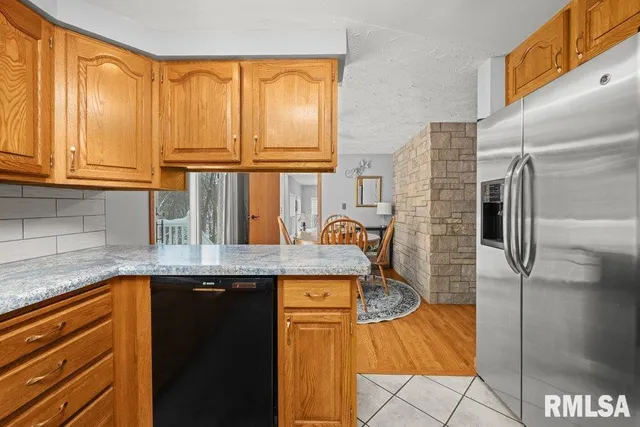 a kitchen with stainless steel appliances granite countertop a sink and a refrigerator