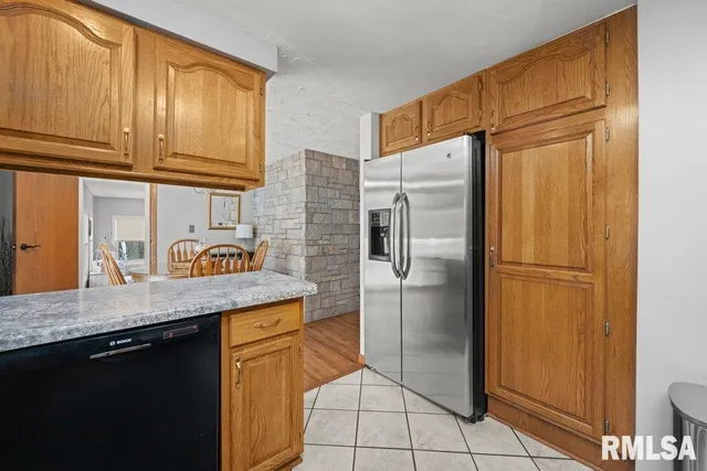 a kitchen with stainless steel appliances granite countertop a refrigerator a sink and cabinets