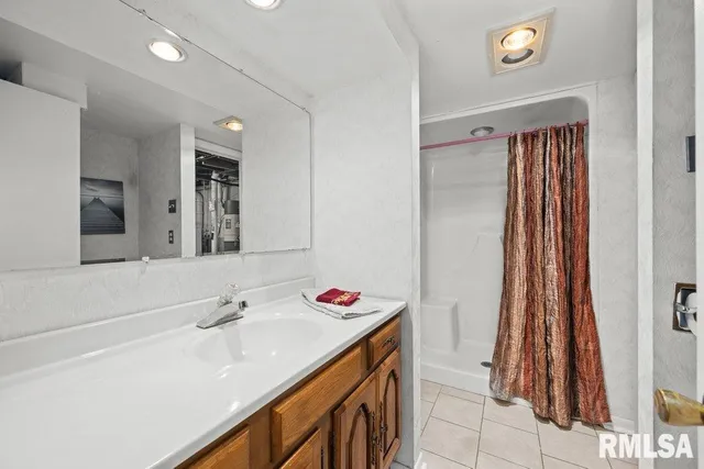a bathroom with a sink vanity and a mirror