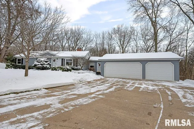 a view of a white house with a yard covered in snow