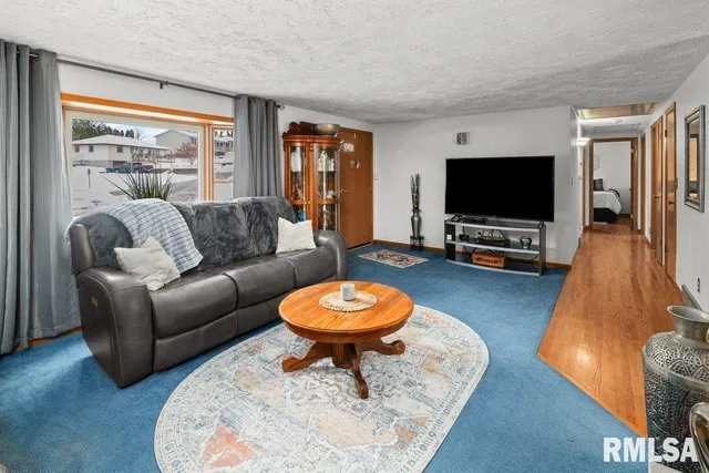 a living room with furniture a flat screen tv and a large window