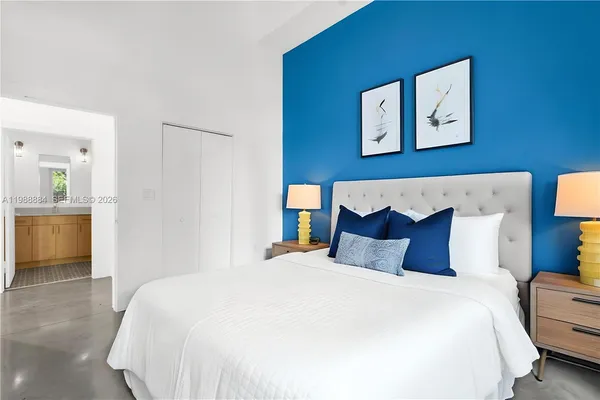 a bedroom with bed and painting on the wall