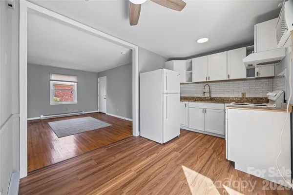 a kitchen with a refrigerator and white cabinets