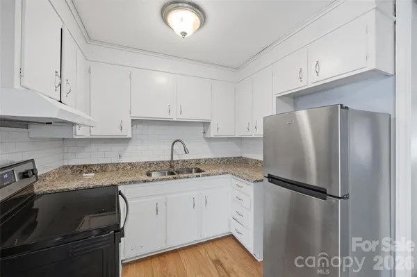 a view of an empty room with a chandelier fan