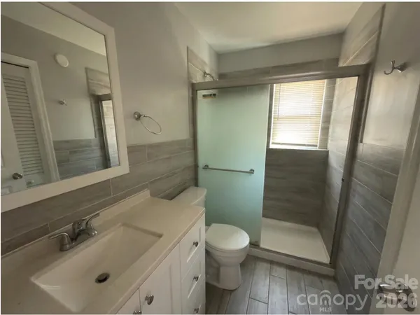 a bathroom with a sink mirror toilet and shower
