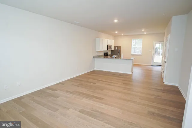 a view of a kitchen with kitchen island a sink wooden floor and a counter top space