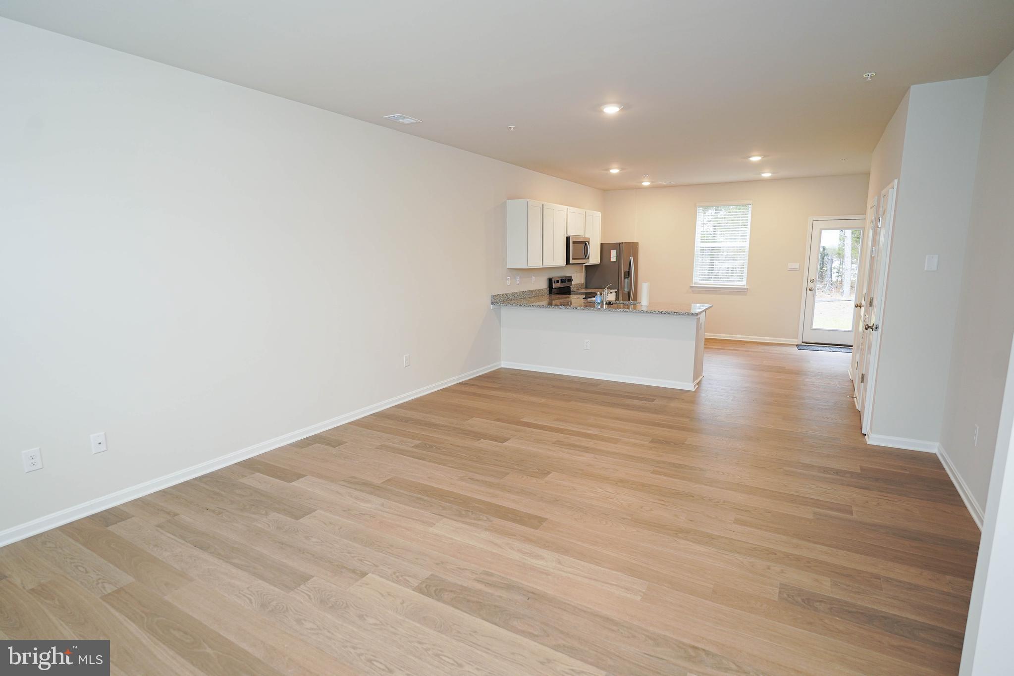852 Mersey Lane Salisbury, MD 21801 - Photo 7 of 40 a view of a kitchen with kitchen island a sink wooden floor and a counter top space