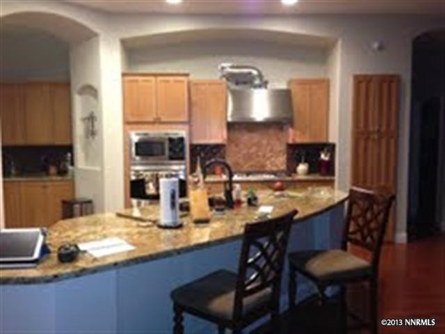 1597 Gemtown Court Reno, NV 89521 - Photo 1 of 1 a kitchen with granite countertop a sink a stove and a wooden cabinets