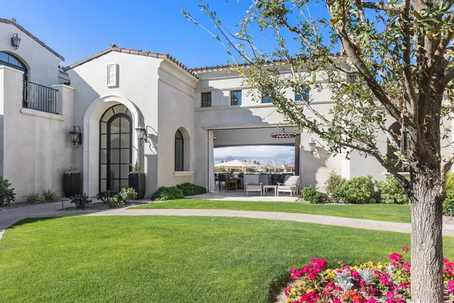 an open kitchen with granite countertop a stove a sink a dining table and chairs with wooden floor