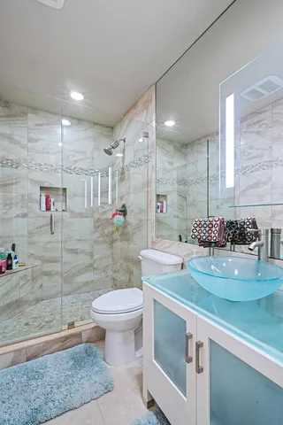 a bathroom with a sink a toilet and shower